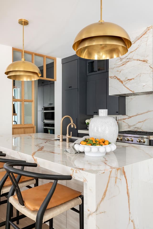 Kitchen area with warm tones and brass pendants