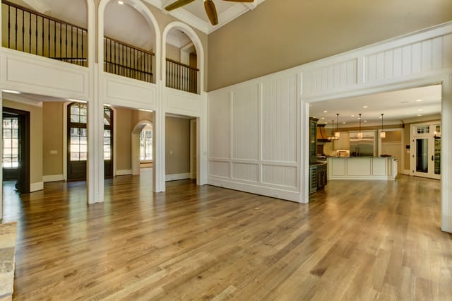 Living Room of Raleigh Home with white wood paneling and arched openings in balcony