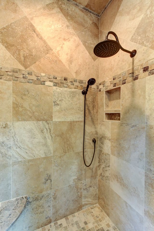 Master Bathroom shower in Raleigh home with tile walls, accents, and floors