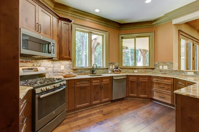 Basement Kitchen in Raleigh home with granite countertops and natural tile backsplash
