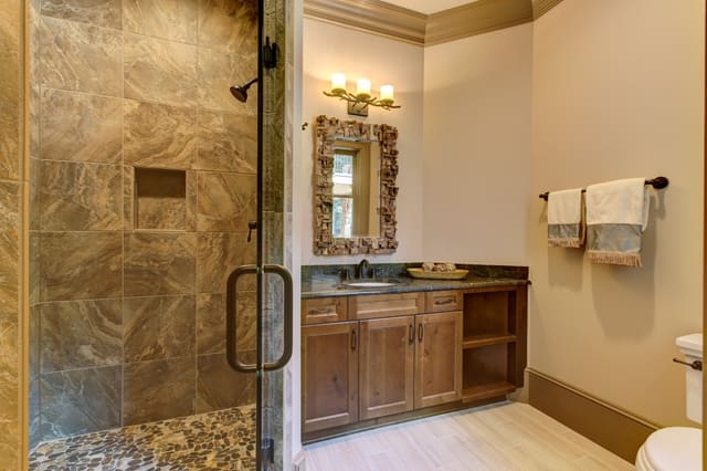 Basement Bathroom in Raleigh home with tiled shower with smooth stone floor