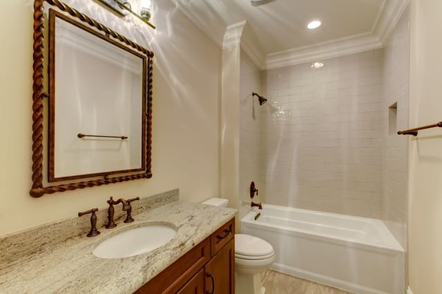 Guest Bathroom in Raleigh home with granite vanity top and white subway tile in shower