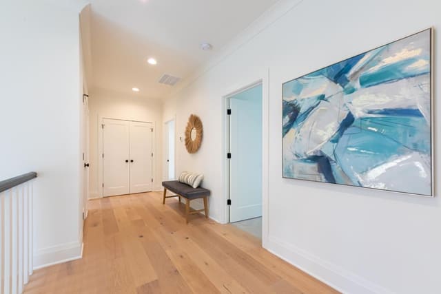 Hallway with brown accent mirror and blue abstract wall art
