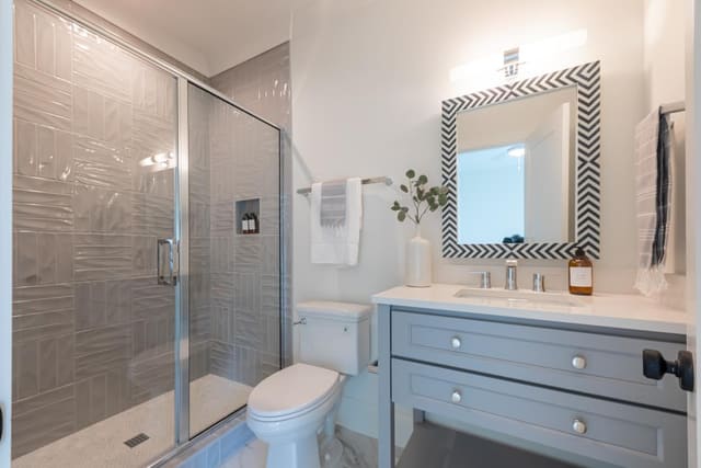 Grey abstract shower wall with black and white mirror