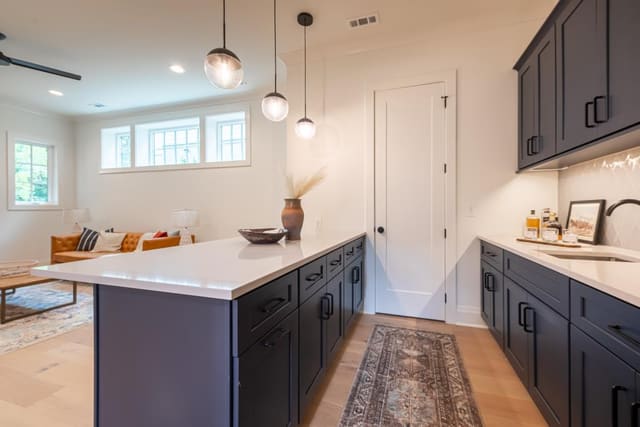 Rec room kitchen area with navy cabinetry