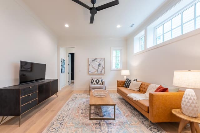 Rec room living area with tan sofa and black and white accents