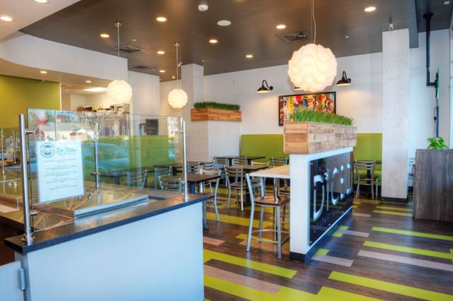 Interior of Diced Restaurant in Raleigh with Custom sign, mixed color LVT flooring, and custom designed greenery box