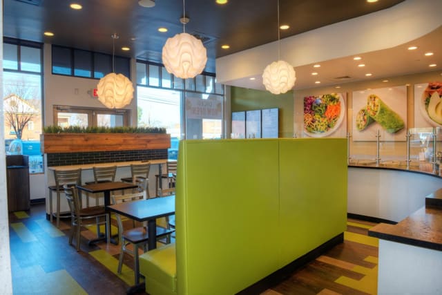 Interior of Diced Restaurant in Cary with colorful LVT Flooring, Green Laminate Banquettes, Black Tables, and Silver Chairs
