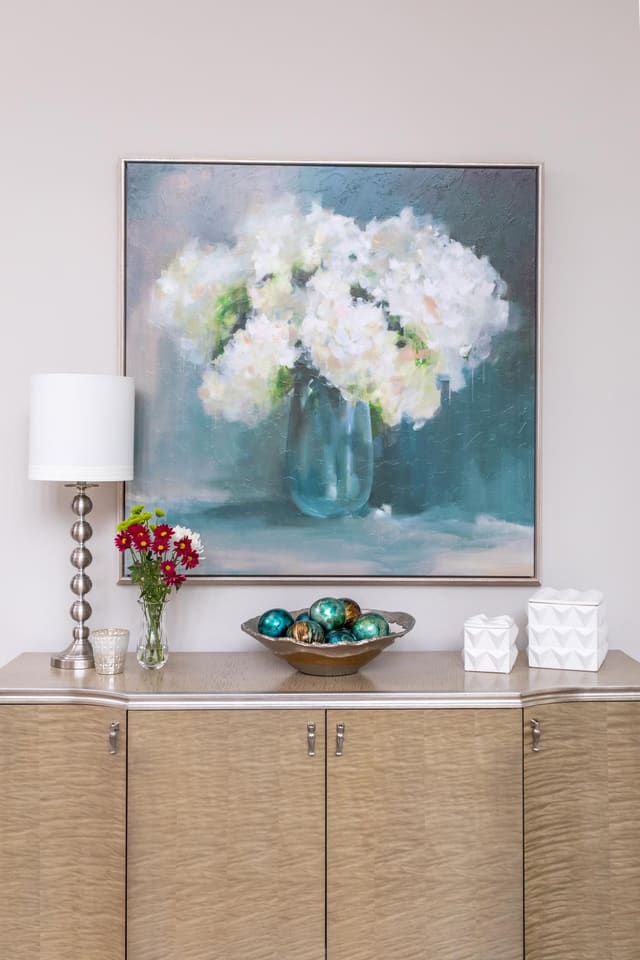 Buffet with framed floral art above.