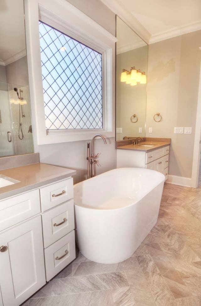 Master Bathroom in new Wake Forest home with freestanding tub, white cabinets, and tile floor.
