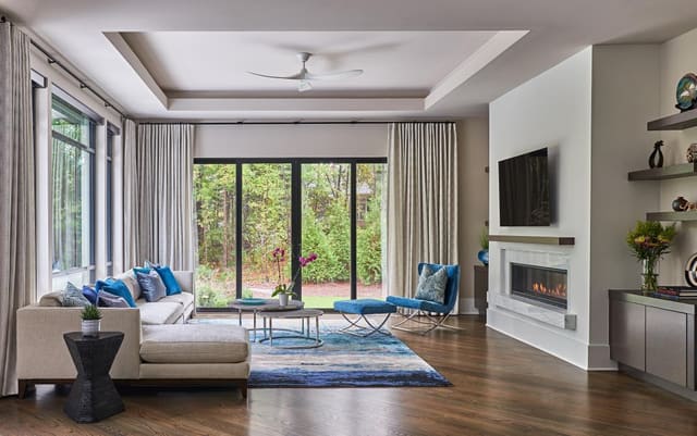 Keeping Room with tray ceiling, inset fireplace, and traversing drapery.