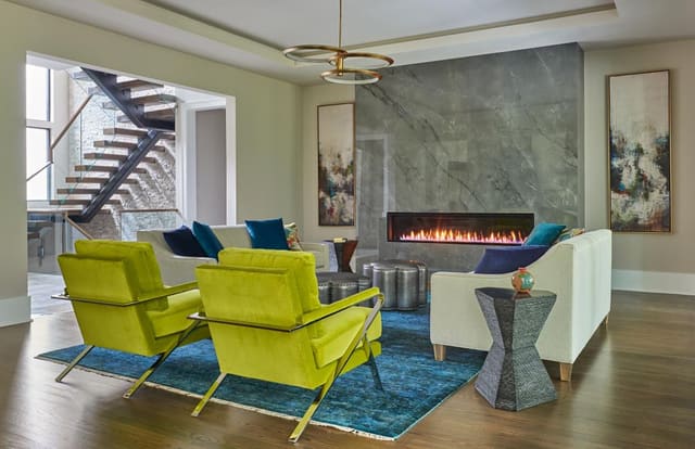Living Room with modern horizontal fireplace, teal rug, lime green chairs and modern light fixture