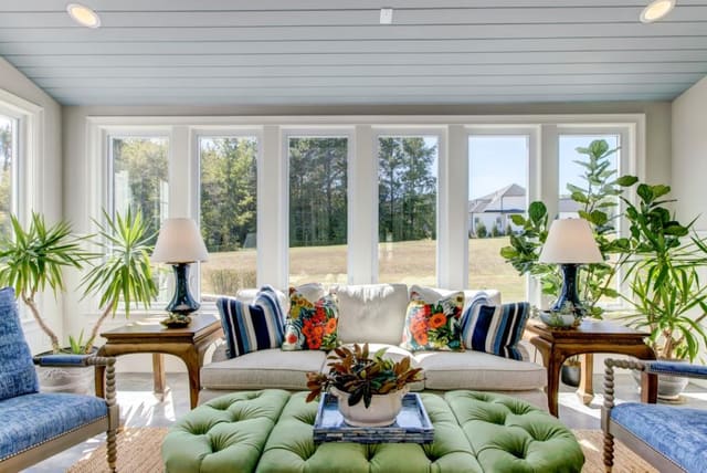 Sun Room with 3 piece ottoman, colorful pillows, and blue chairs and lamps