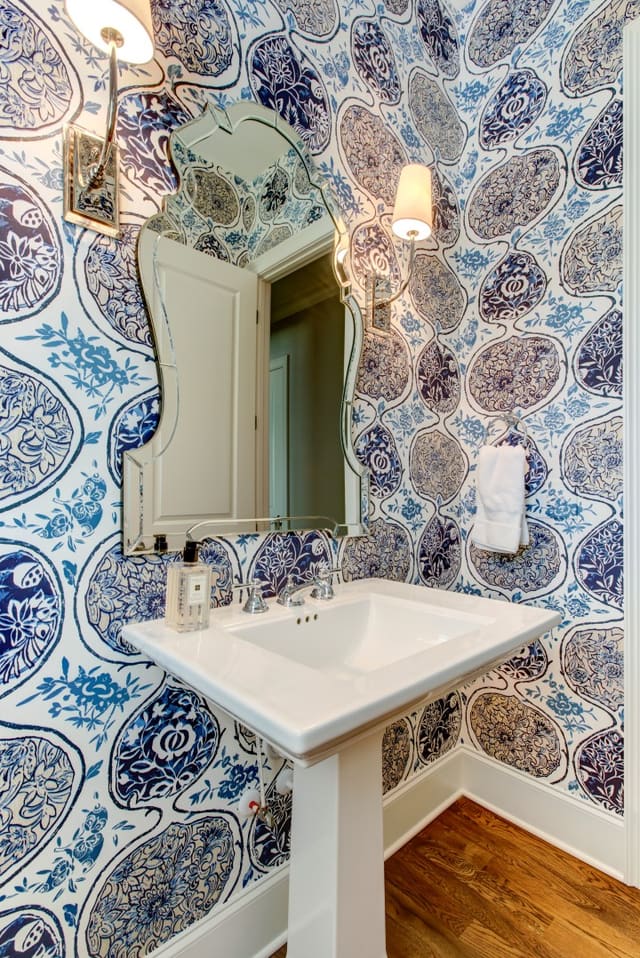 Powder Room with blue patterned wallpaper and curved mirror